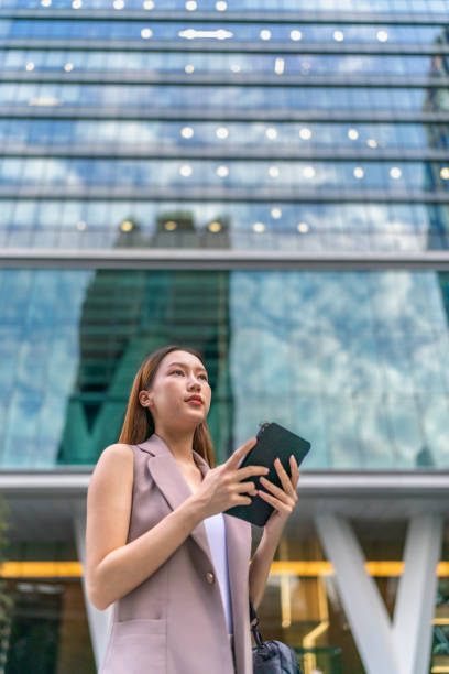 istock Efficiency Unleashed. Young Asian Businesswoman Empowers Business on the Go With A Digital Tablet Against a Contemporary Corporate Buildings in a Central Business District 1600609099