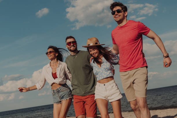 istock Group of happy young friends bonding and smiling while spending time on the beach together 1600611531