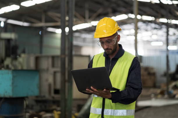 istock Male engineer worker working with laptop computer for control machine in factory. Male worker working with CNC machine with safety uniform, helmet in industry factory 1600625440