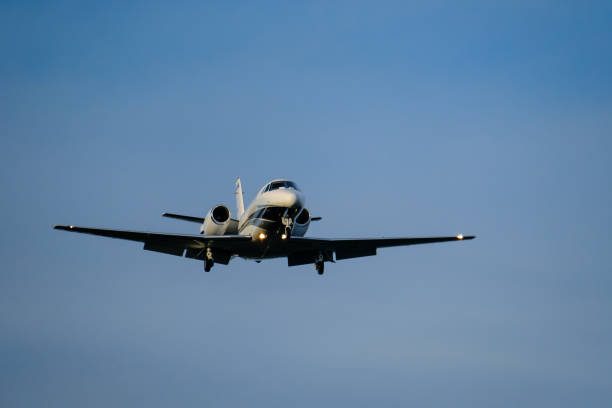 A small business jets approaching the airport with landing lights on. stock photo