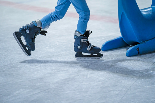 Close-up of a girl's legs in w fashion skates on an outdoor ice rink, a young girl skating thinking on the open rink
