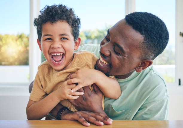 vater, lachen und schwarzer mann kitzeln sohn, haben spaß und genießen sie eine glückliche zeit zusammen in jamaika zu hause. familienbindung, kinderliebe und spielende afrikaner, jugendkind oder papa kitzelnder lachender junge - tickling stock-fotos und bilder