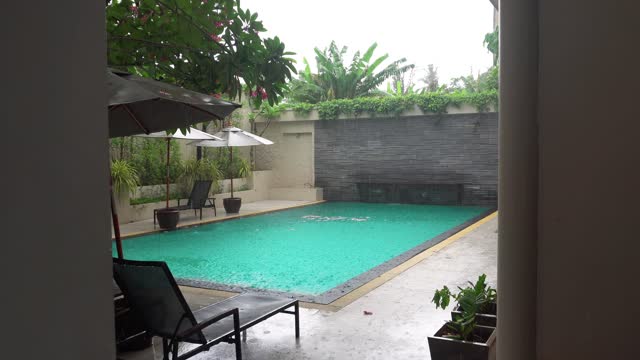 Raindrops on pool water in hotels. Heavy downpour