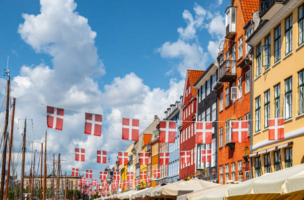 デンマークのコペンハーゲン、ニューハウンにあるデンマークの旗とカラフルな建物。 - denmark house flag danish flag ストックフォトと画像