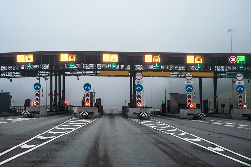 A toll collection point at a multi-lane highway at foggy morning