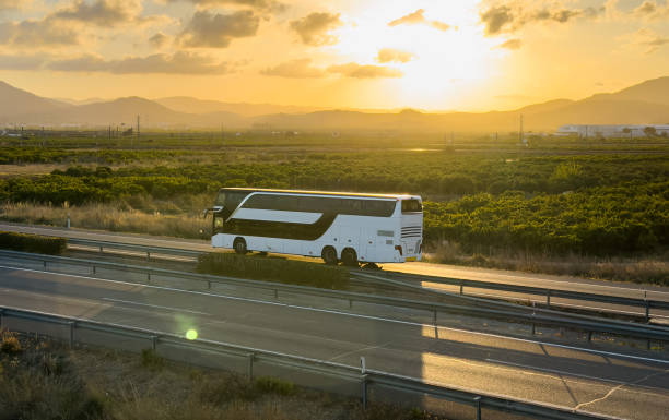Bus on highway on sunset. Tour Bus driving on highway road.