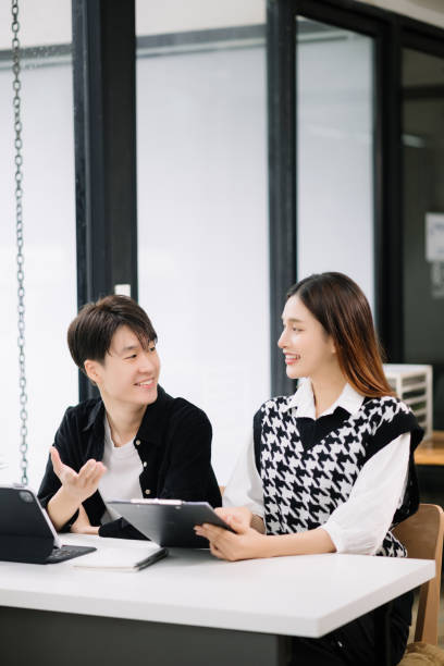 istock Two Asian business workers talking on the smartphone and using laptop at the modern office. 1600715747