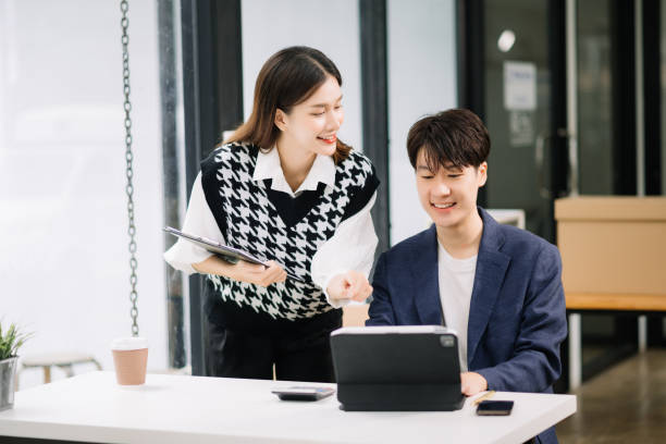 istock Two Asian business workers talking on the smartphone and using laptop at the modern office. 1600715799