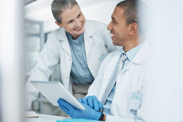 istock Scientist people, tablet or teamwork in science laboratory for medical research, training or medicine collaboration. Happy mature woman, mentor or technology in healthcare help or genetic engineering 1600719351