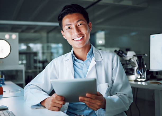 istock Tablet, portrait and scientist with digital innovation, data and smile in laboratory. Asian man, doctor and information technology for futuristic medical research with online pharma healthcare study 1600719554