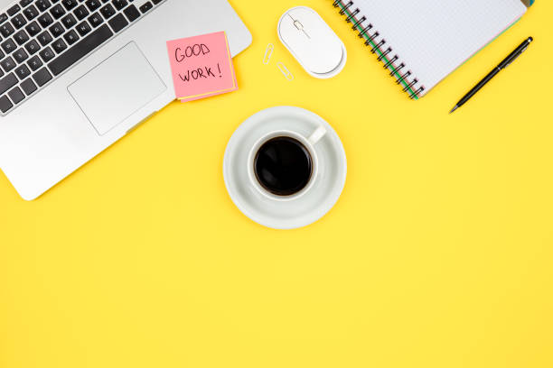 istock Laptop, notepad and coffee cup on yellow background, top view. 1600721799