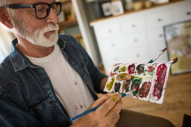 istock Elderly man painting on a canvas at home 1600727295
