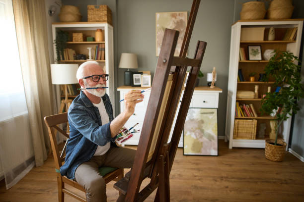 istock Elderly man painting on a canvas at home 1600727830