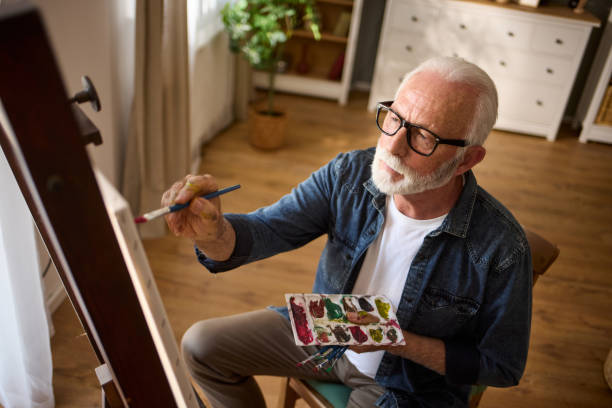 istock Elderly man painting on a canvas at home 1600727869