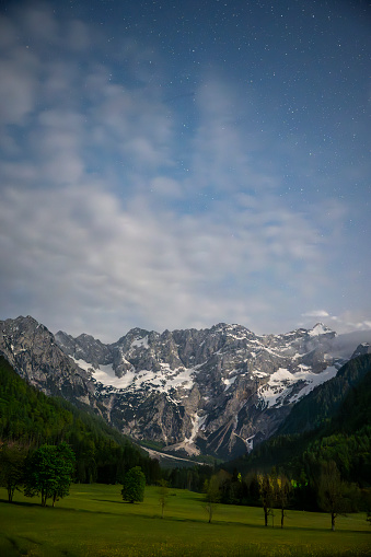 Zgornje Jezersko valley in Slovenia nighttime view with a starry night over the mountains  during a beautiful springtime night with the mountain range around the Grintovec mountain peak in the Kamnik–Savinja Alps.