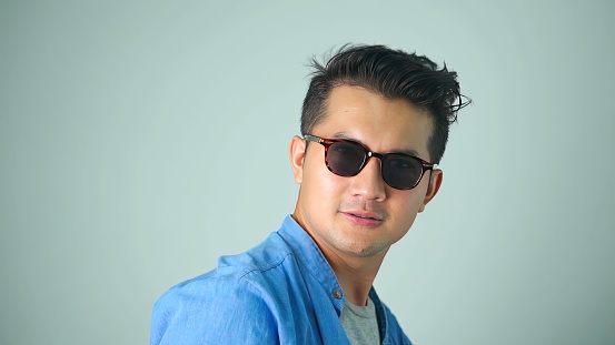 Asian man handsome wearing sunglasses gesture thumb up white background