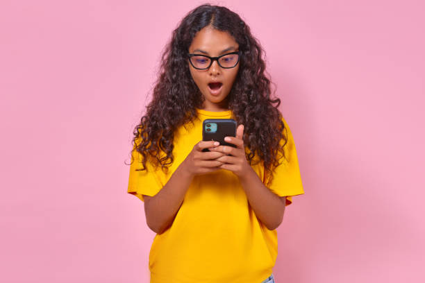 istock Young surprised attractive Indian woman student with phone stands in studio 1600765280