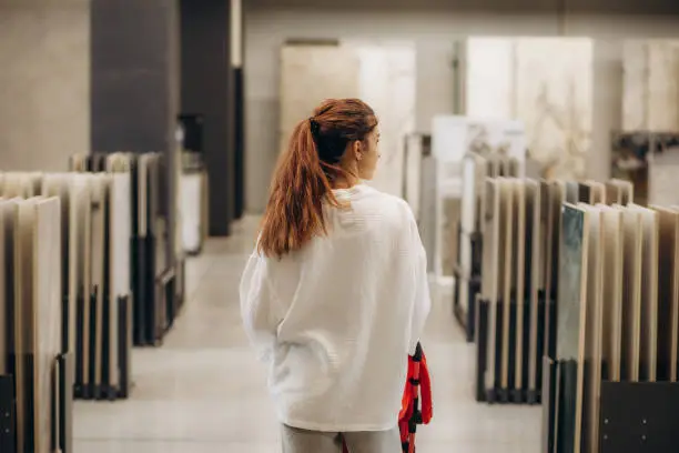 a young mother with a child in her arms chooses tiles for home.