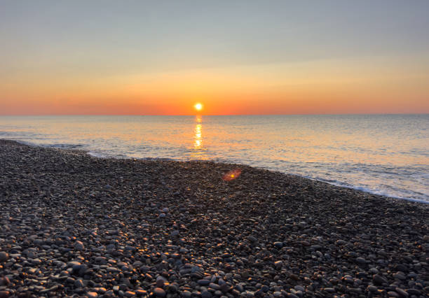 istock Waves in sea on sunrise. Pebble stone beach on sunset. 1600772400