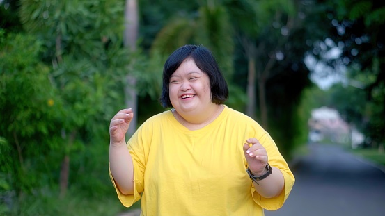 Looking at the clock, an Asian girl with Down syndrome rejoices.As I exercised in the park.