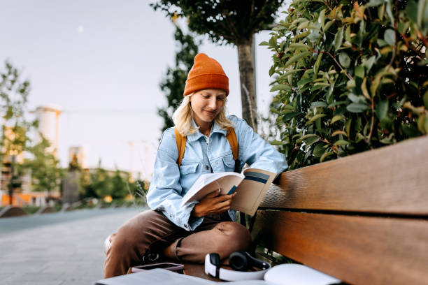 istock Young beautiful woman studying outdoors on a bench 1600786257