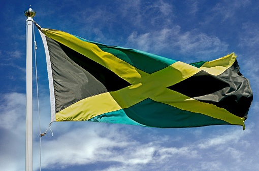 flag of Jamaica or Jamaican banner on wooden background