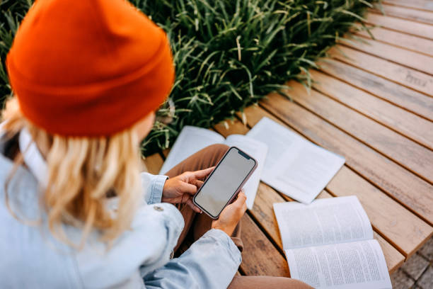 istock Young woman using phone while studying outdoors 1600788401