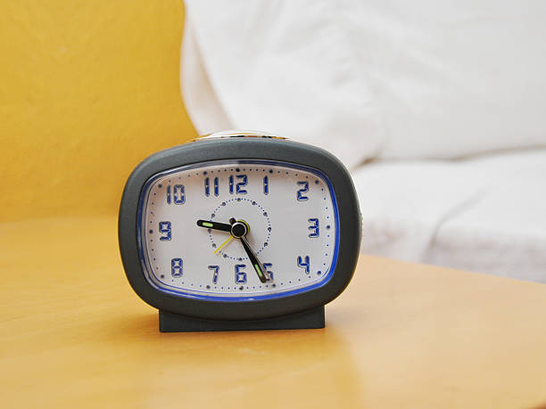 istock Alarm clock on nightstand next to bed 160083133