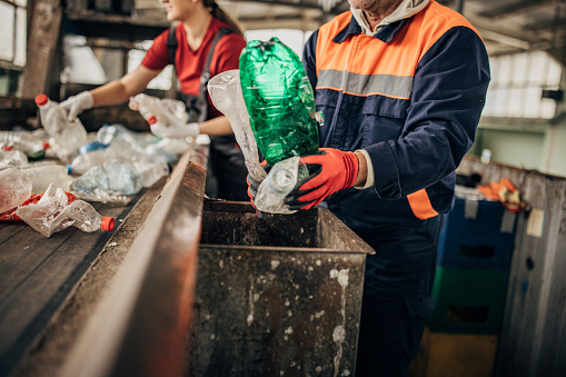 Group of workers at the recycling centre sorting plastic waste ad preparing for recycling