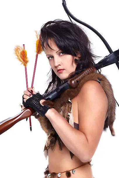 full-length portrait of beautiful woman fur hunter with crossbow on gray