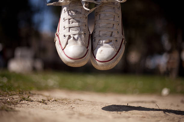 young woman jumping at the park stock photo