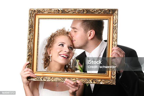 Bride And Groom Holding Up Empty Picture Frame Around Faces Stock Photo - Download Image Now