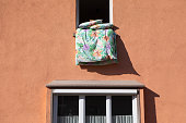 Laundry hanging out of a window to dry