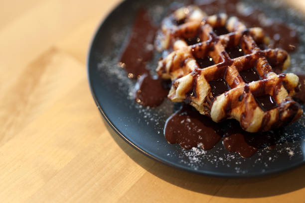 istock A Belgian waffle topped with chocolate spread and dusted with icing sugar. 1600895354