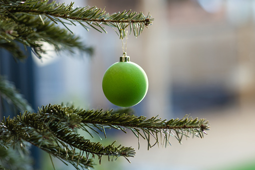 A close up selective focus front view of a single felt bauble on a Christmas tree in a families home in Newcastle upon Tyne in the North East of England
