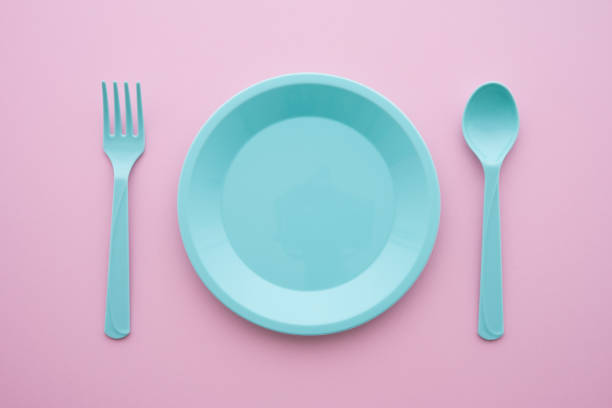 istock Flat lay of empty blue pastel plastic dish, spoon and fork on pink background. 1600936778