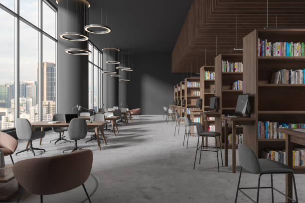 istock Modern library interior with table and chairs in row, bookshelf and window 1600953080