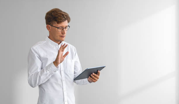 istock Businessman waving hand to tablet screen, copy space white background 1600962412