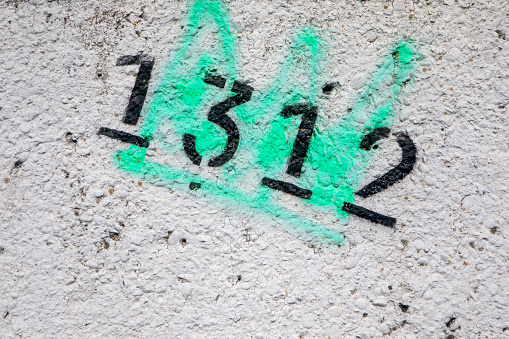 A telephone junction box daubed with graffiti. The box is situated outside the Brighton & Hove School in Hove, Sussex, England. The most prominent tag is \