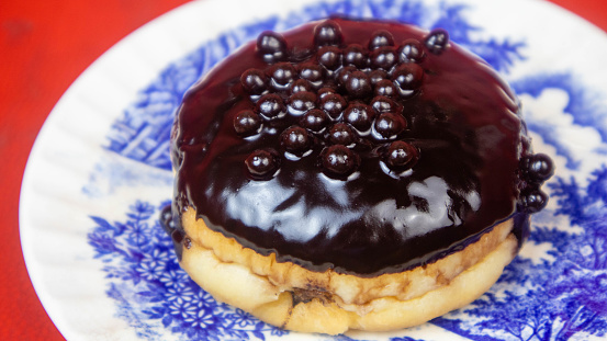 a chocolate donuts on a plate on a red background