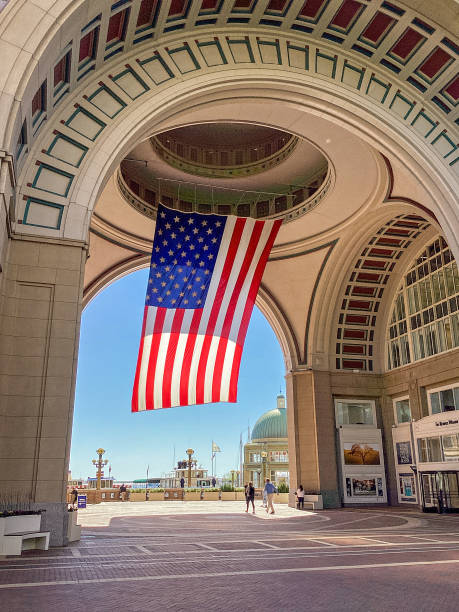 uma bandeira americana gigante pendurada no arco e edifícios em rowes wharf em boston, massachusetts - rowes wharf - fotografias e filmes do acervo