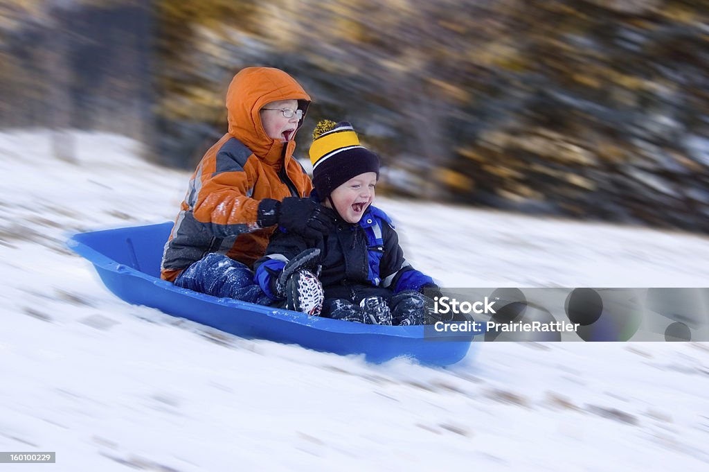 Excited Boys on Sled Ride 2 Excited Young Boys Share Sled Ride in Snow Sledding Stock Photo