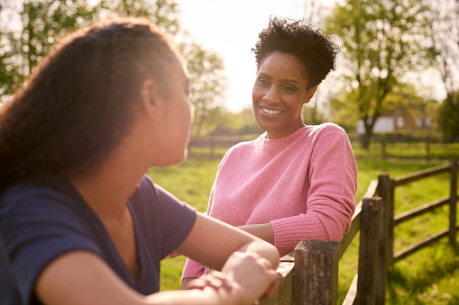 Mature Mother With Teenage Daughter Enjoying Walk In Countryside Together