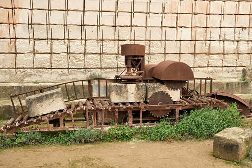 Antique metal old machine with gears and rectangular rocks for making stones historical monument in Spain