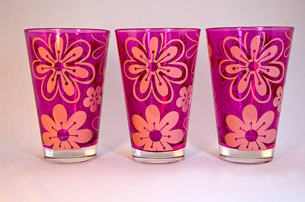 Three pink drinking glasses with flower design stock photo