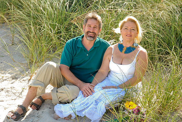 Couple siting on beach stock photo