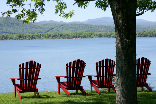 Adirondack chairs facing Lake Champlain and the Adriondack Mountains.