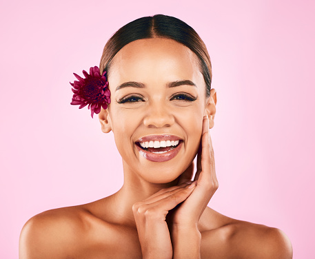 Natural beauty, flower and portrait of woman with makeup, wellness and skin care glow on pink background. Cosmetics, organic dermatology and model with luxury facial care and healthy spa in studio.