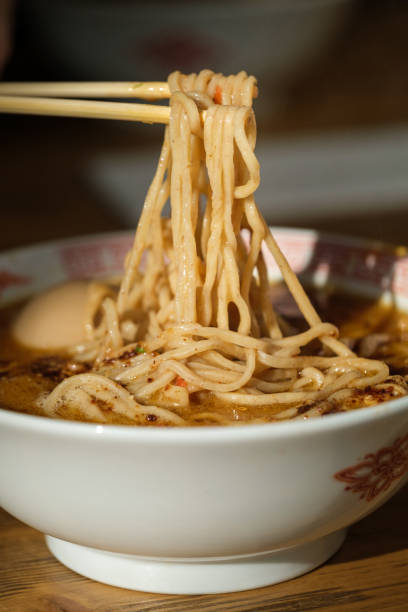 istock Anonymous person with chopsticks taking noodles from bowl 1601033520