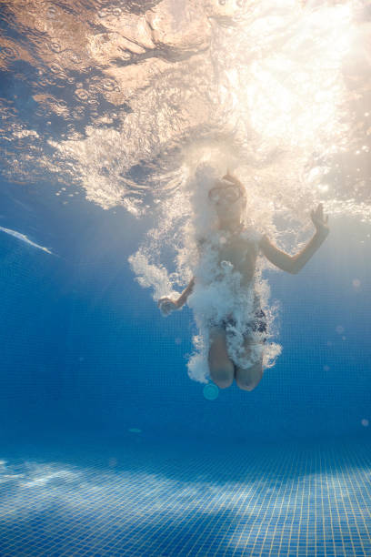 istock Small boy swimming in bubbling water in pool 1601037252